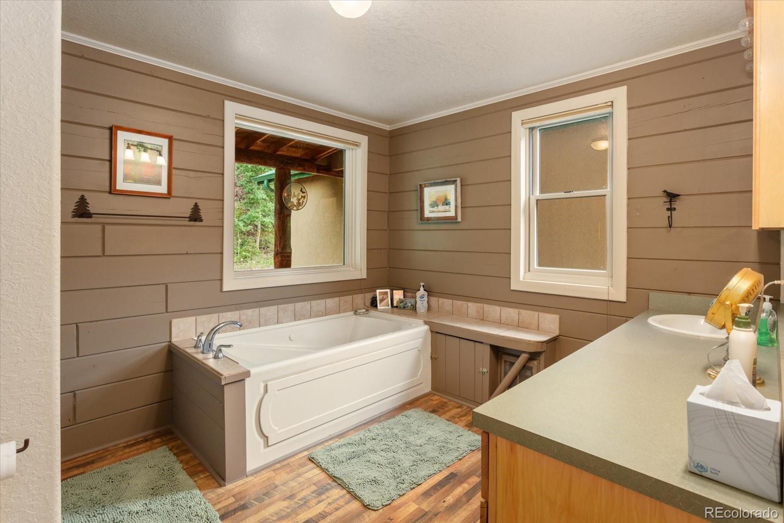 1021 Silver Lakes Road Villa Grove, CO 81155 - Photo 21 of 50 a bathroom with a tub a sink and a window