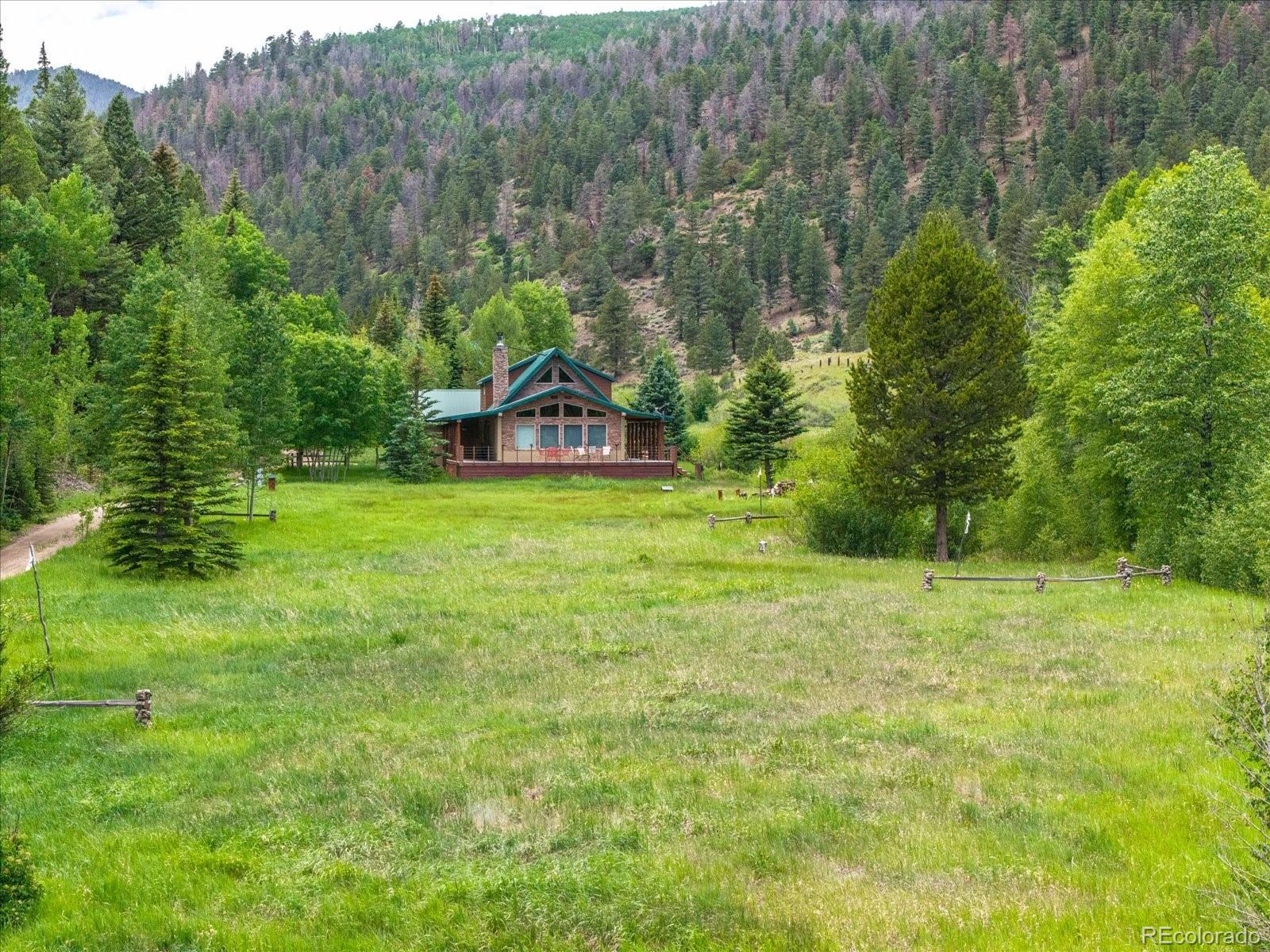 1021 Silver Lakes Road Villa Grove, CO 81155 - Photo 42 of 50 a view of a house with a big yard and large trees