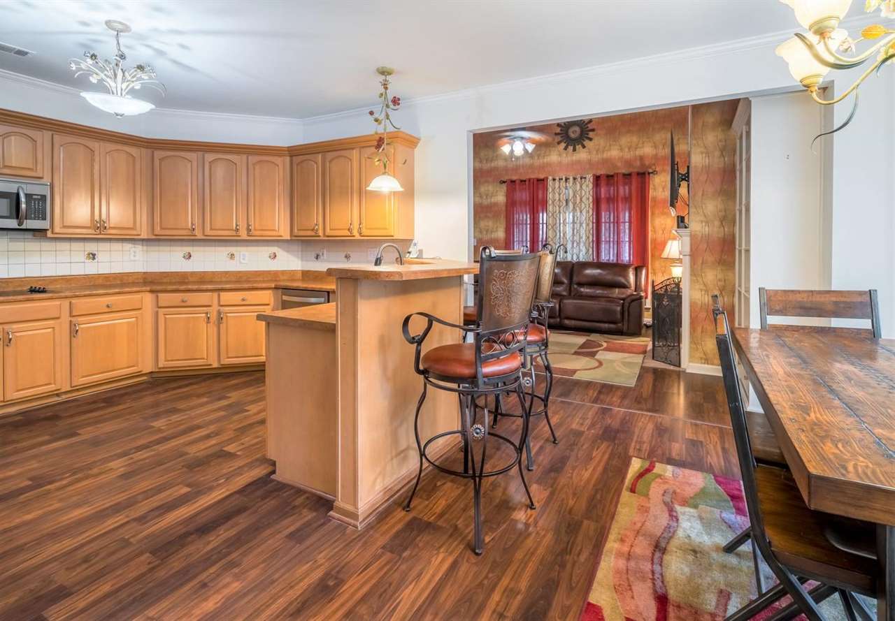 10553 Godwin Road Arlington, TN 38002 - Photo 4 of 16 a kitchen with stainless steel appliances granite countertop a stove top oven a sink dishwasher and cabinets with wooden floor