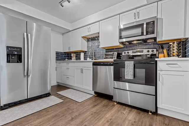 a kitchen with stainless steel appliances a stove microwave and a refrigerator