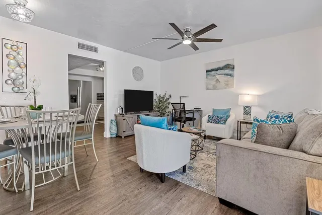 a living room with furniture and a wooden floor