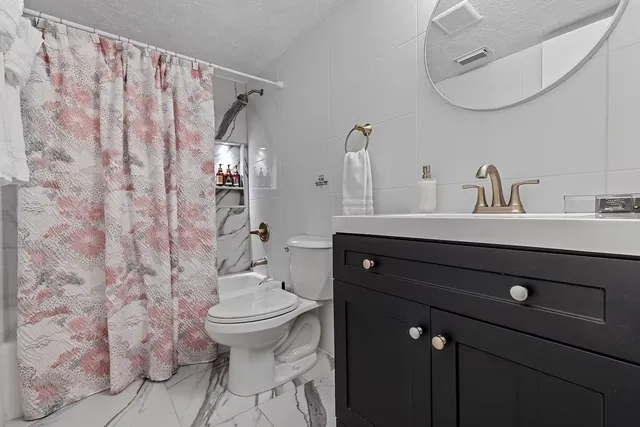 a bathroom with a granite countertop sink a toilet and a mirror