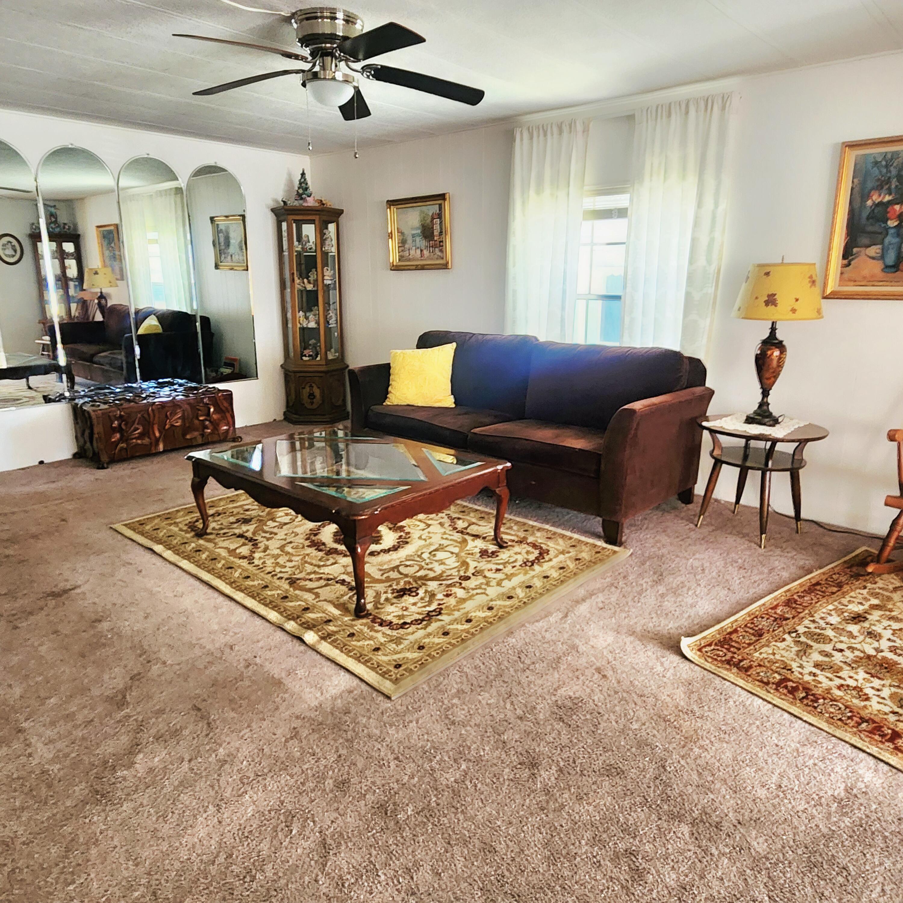 98 Camino Del Rio Port St. Lucie, FL 34952 - Photo 15 of 60 a living room with furniture a chandelier and a rug