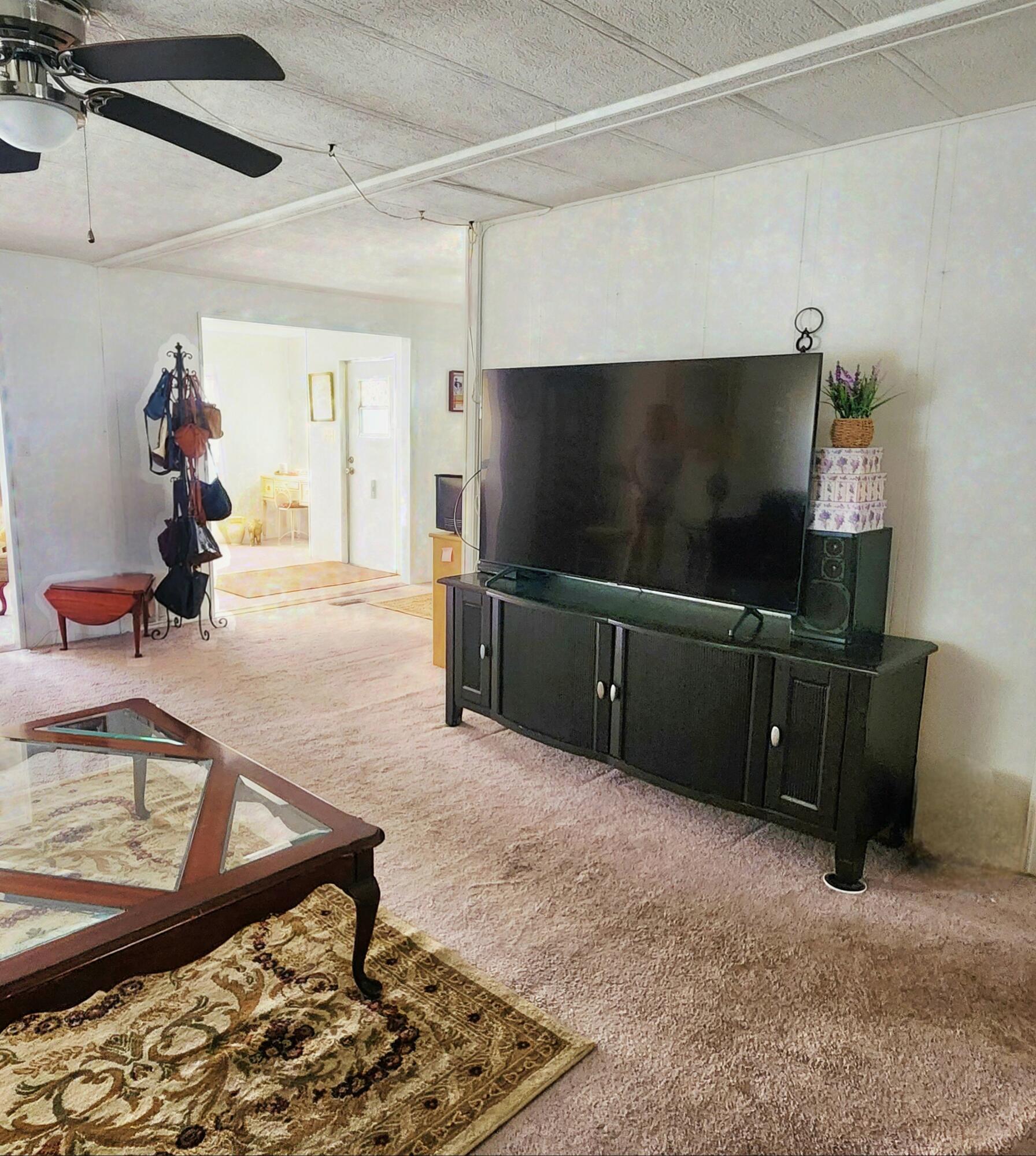98 Camino Del Rio Port St. Lucie, FL 34952 - Photo 16 of 60 a living room with furniture and a flat screen tv