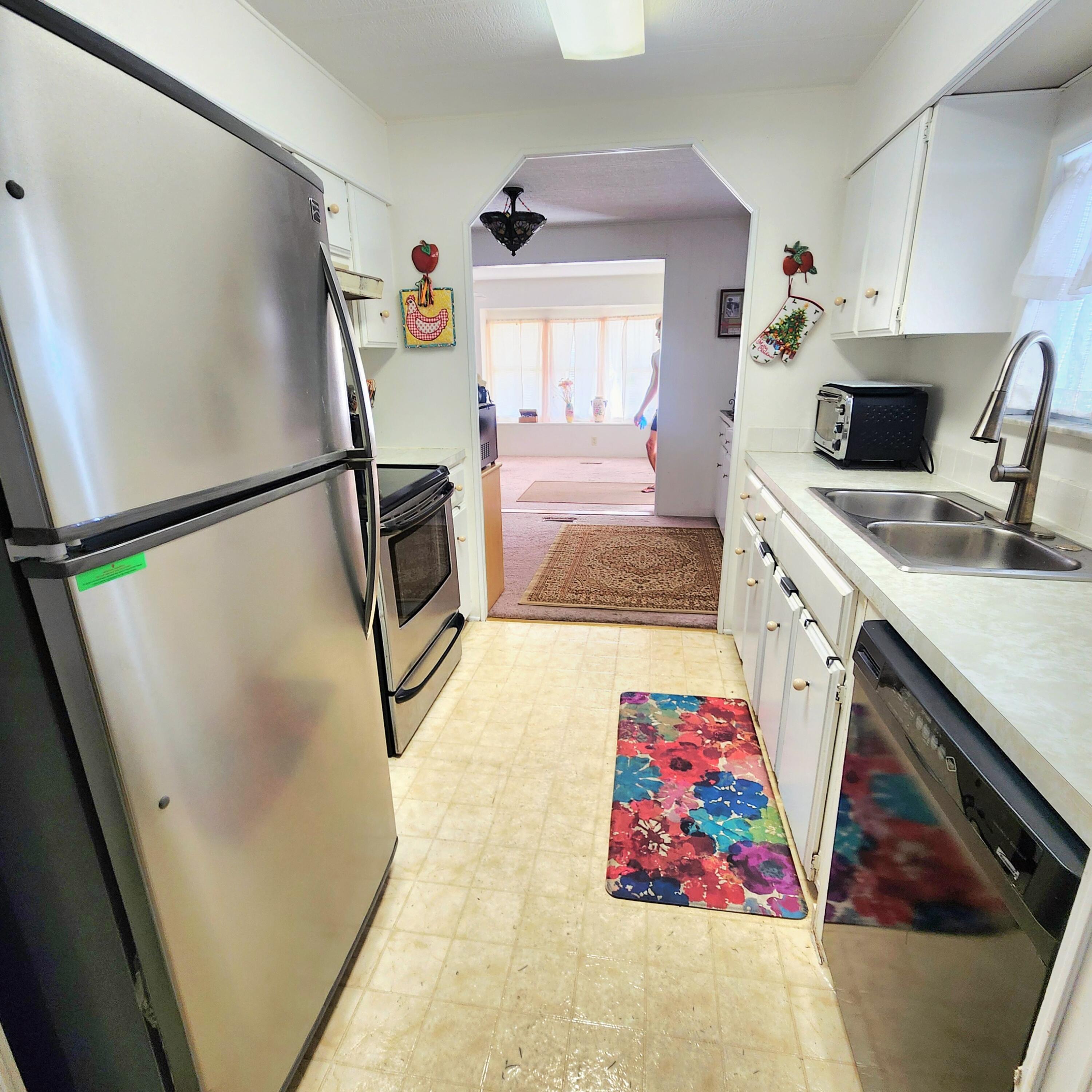 98 Camino Del Rio Port St. Lucie, FL 34952 - Photo 19 of 60 a kitchen with a refrigerator sink and wooden floor
