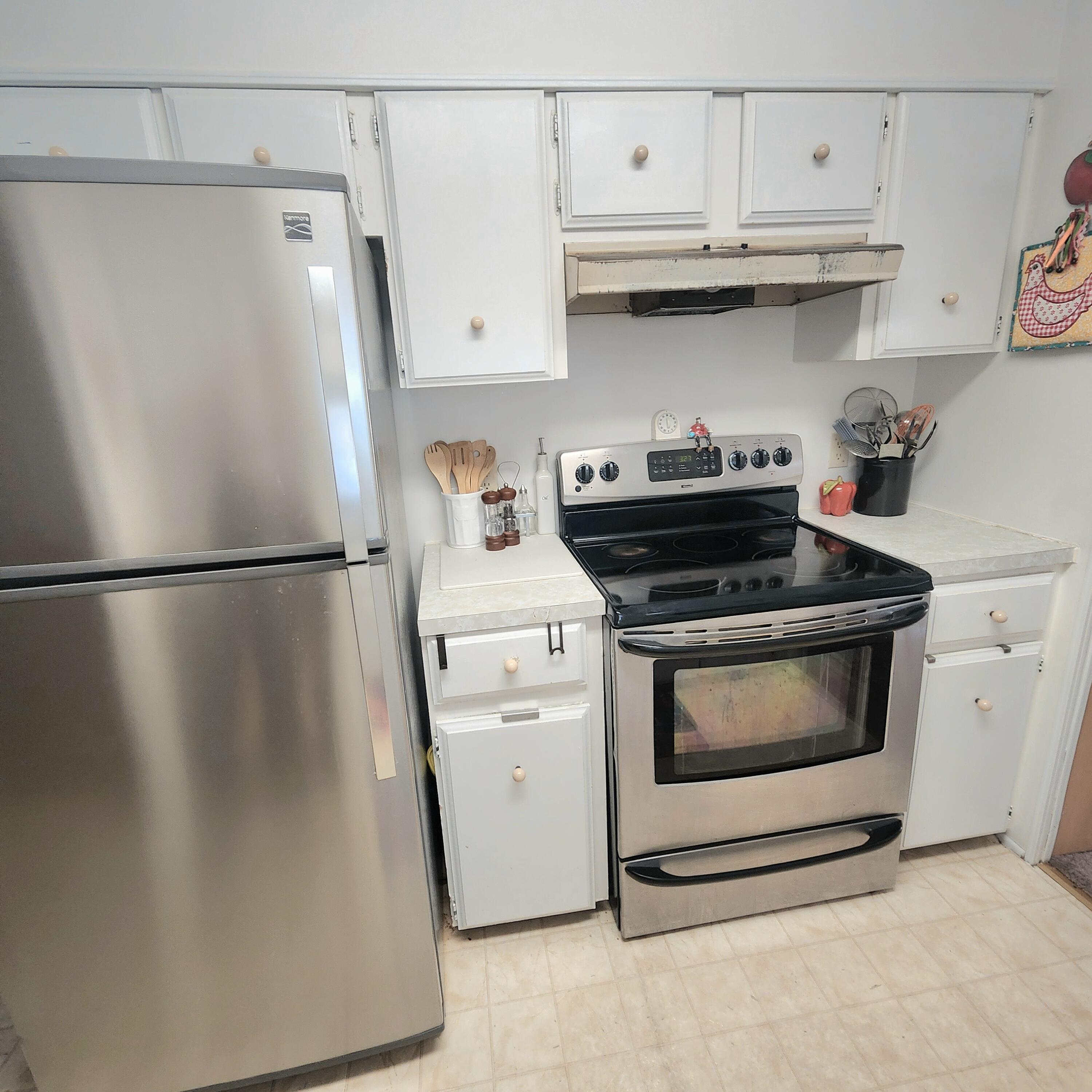 98 Camino Del Rio Port St. Lucie, FL 34952 - Photo 20 of 60 a kitchen with white cabinets and white appliances