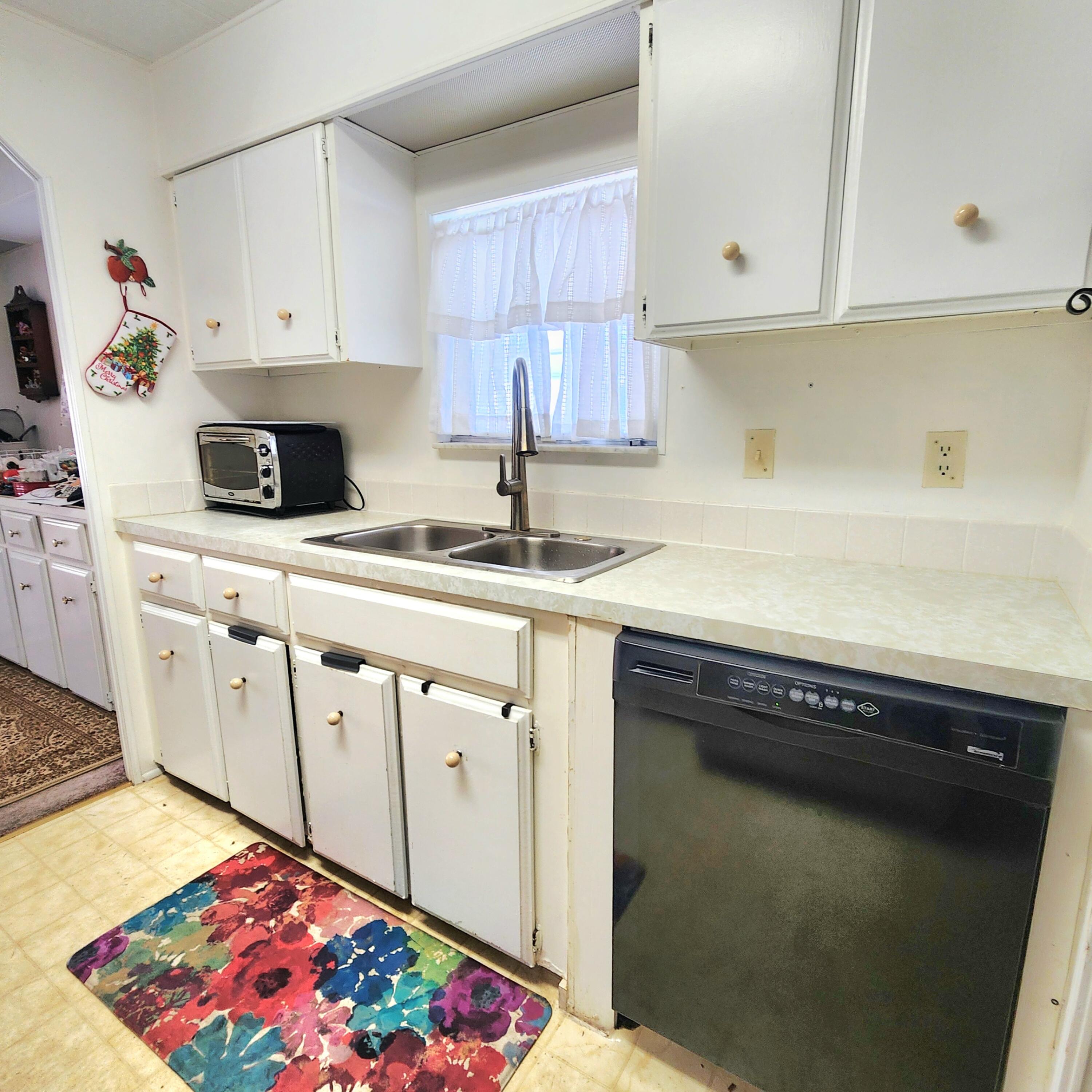 98 Camino Del Rio Port St. Lucie, FL 34952 - Photo 21 of 60 a kitchen with granite countertop white cabinets and black appliances