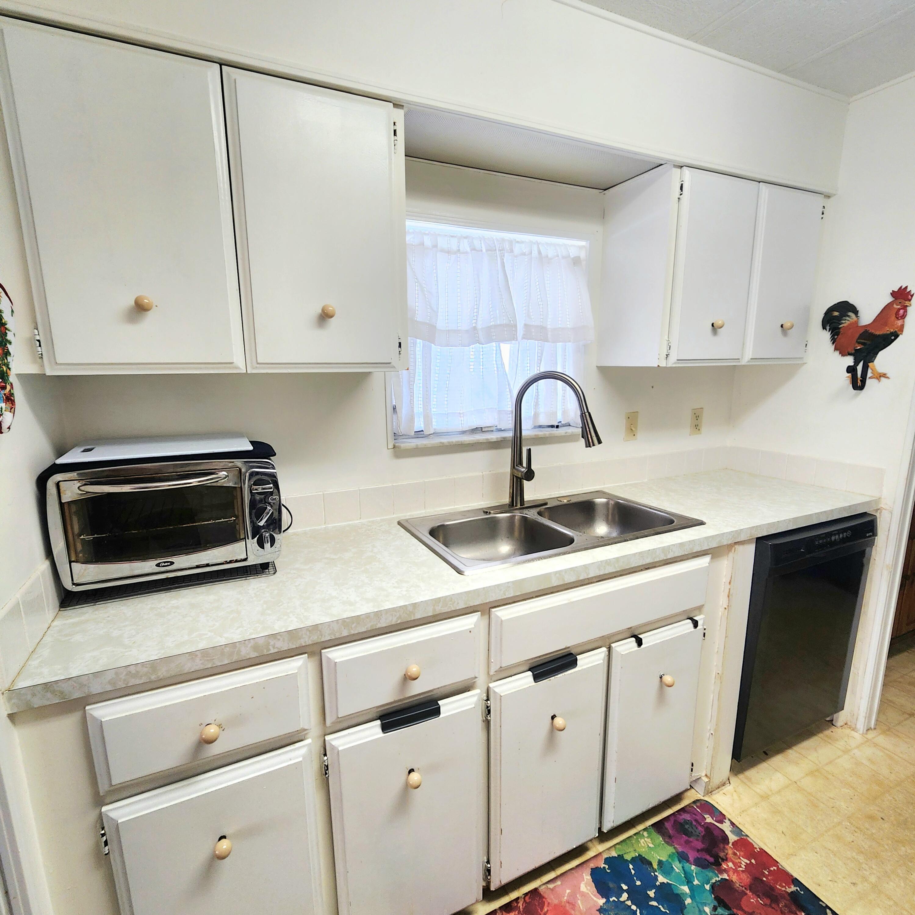 98 Camino Del Rio Port St. Lucie, FL 34952 - Photo 22 of 60 a kitchen with a sink microwave and cabinets