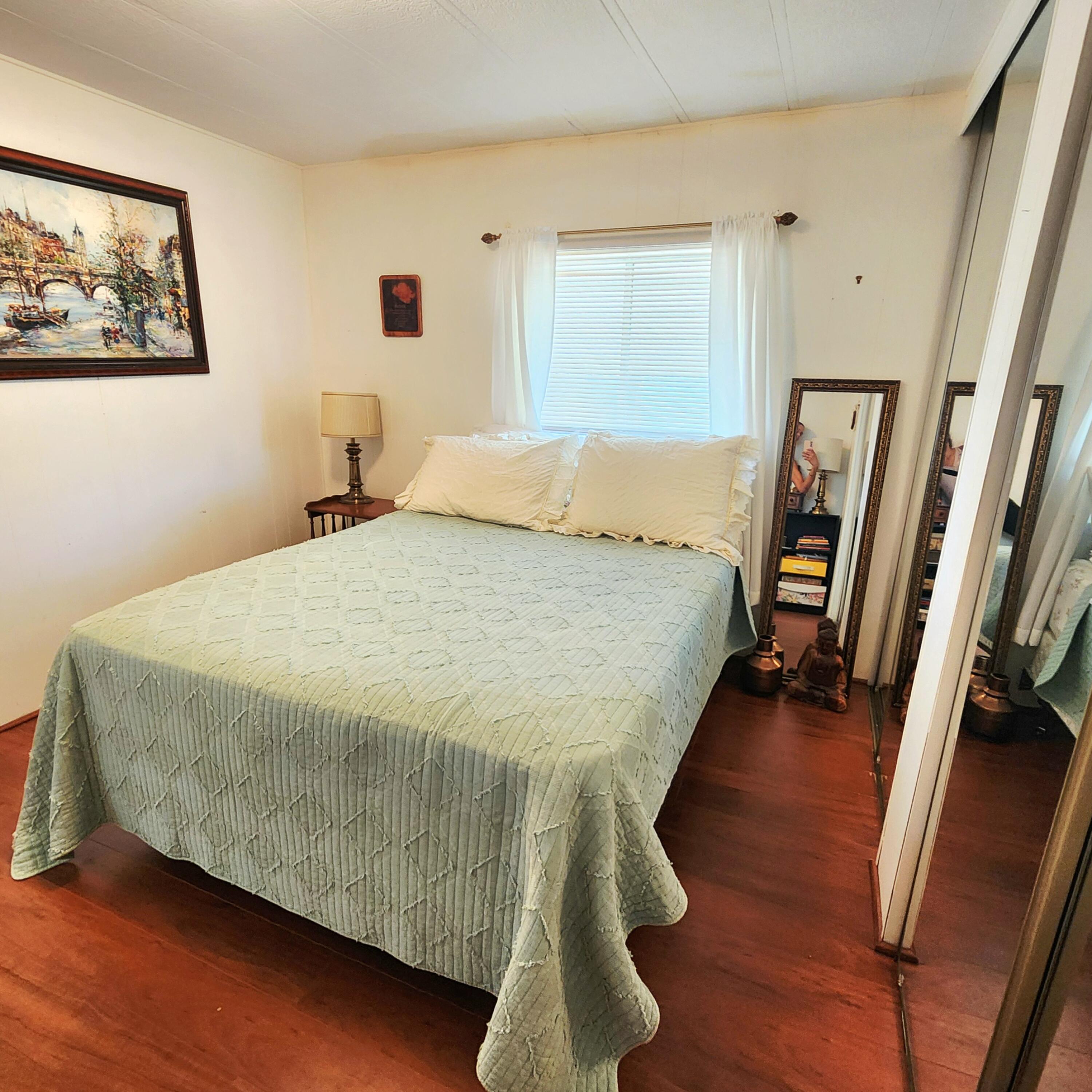 98 Camino Del Rio Port St. Lucie, FL 34952 - Photo 26 of 60 a bedroom with a bed and a large mirror