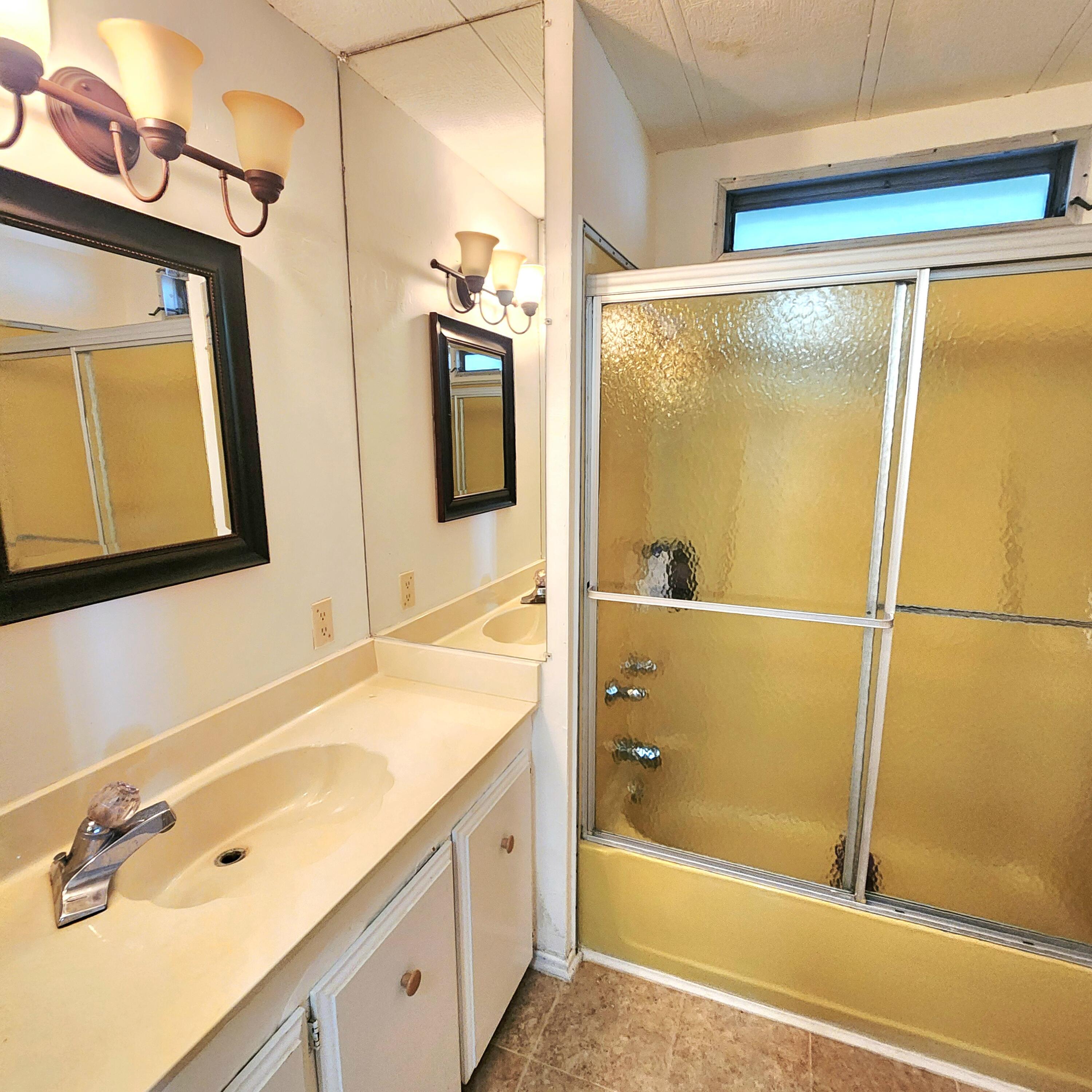 98 Camino Del Rio Port St. Lucie, FL 34952 - Photo 28 of 60 a bathroom with a tub a sink and a mirror