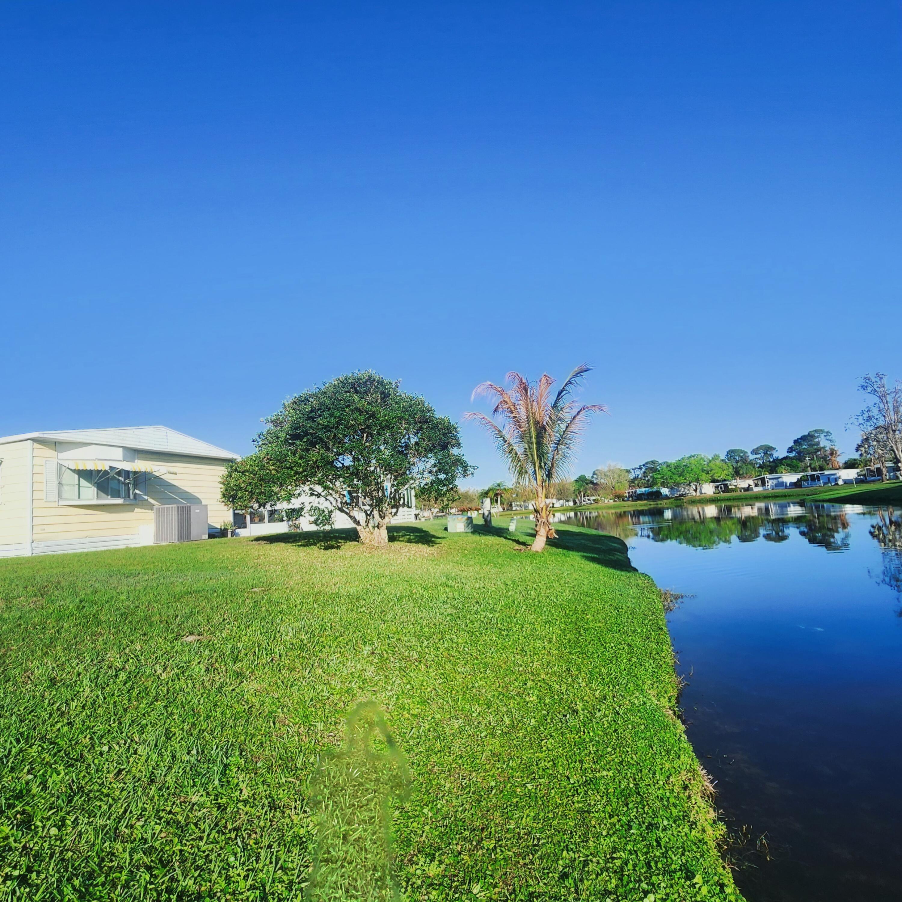 98 Camino Del Rio Port St. Lucie, FL 34952 - Photo 51 of 60 a view of a garden with a building in the background