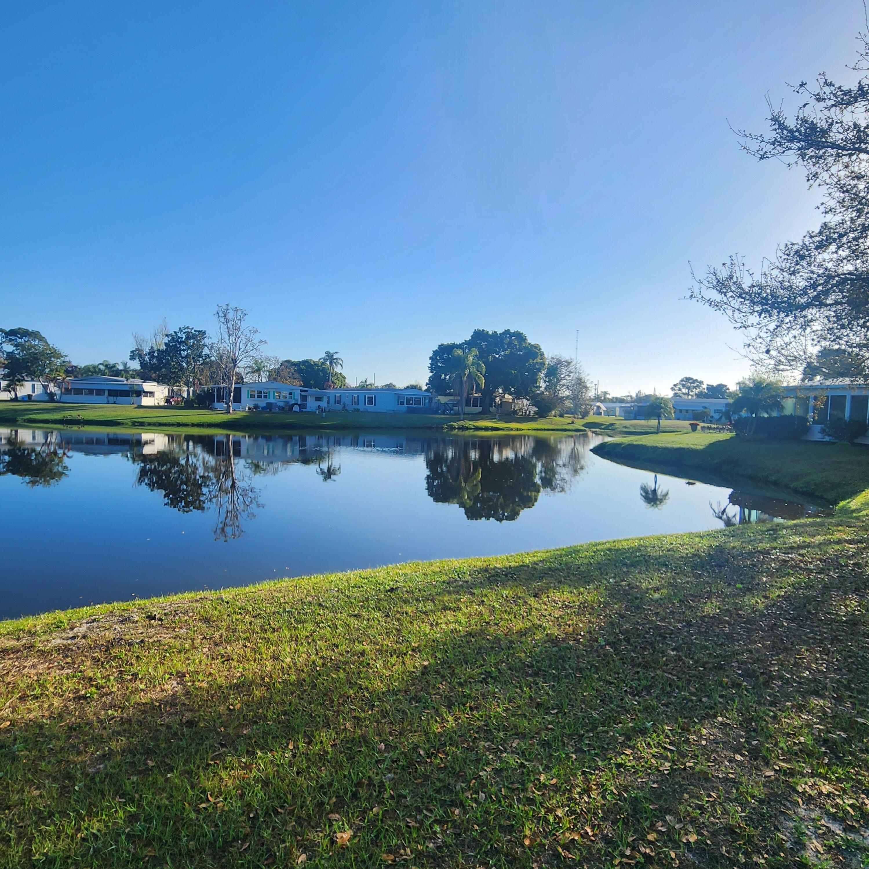 98 Camino Del Rio Port St. Lucie, FL 34952 - Photo 52 of 60 a view of a lake with houses in the back