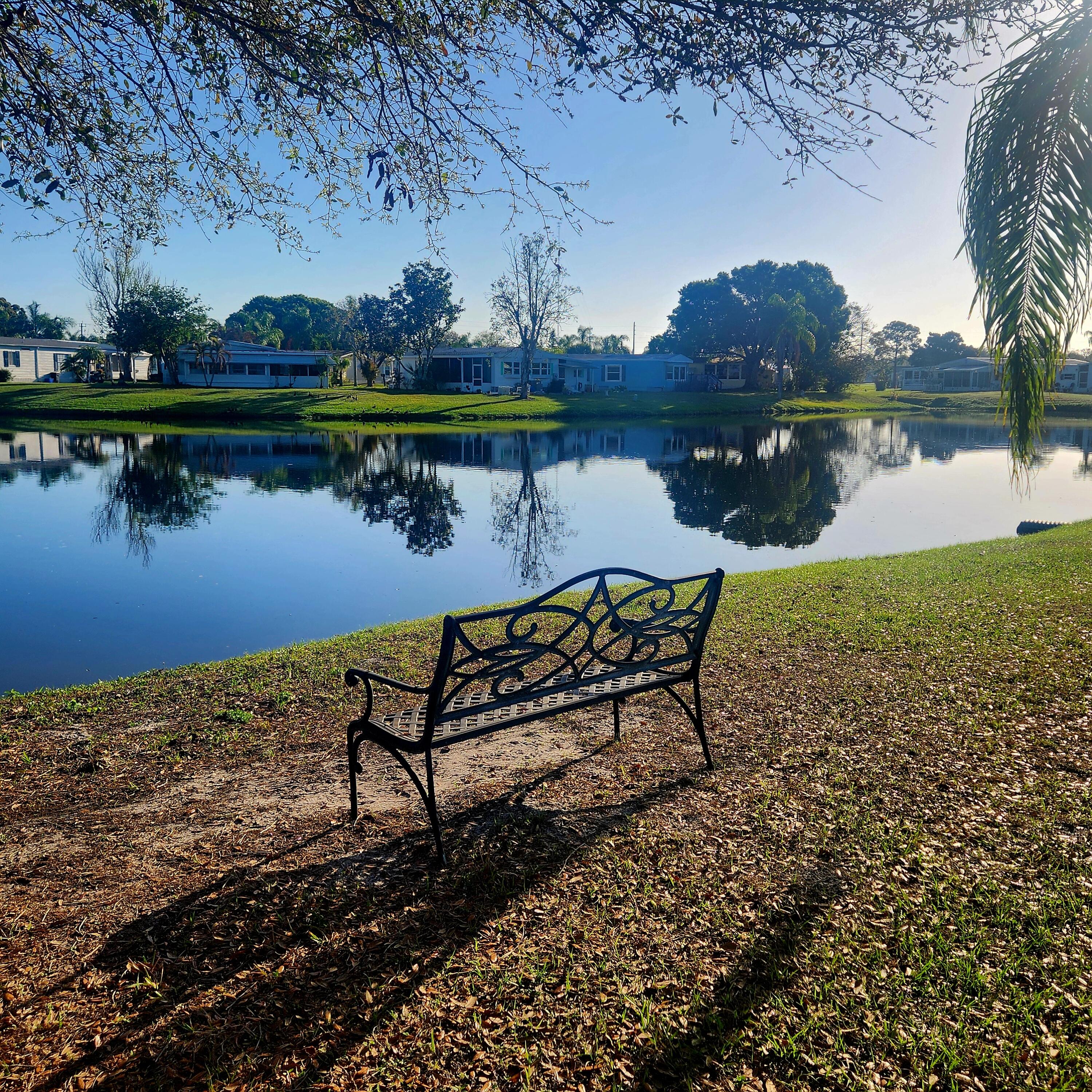 98 Camino Del Rio Port St. Lucie, FL 34952 - Photo 59 of 60 a view of a lake with a table and chairs