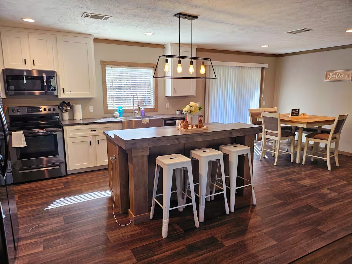 105 Saddle Surrey Road Coldspring, TX 77331 - Photo 21 of 48 a kitchen with stainless steel appliances granite countertop wooden floors stove and white cabinets