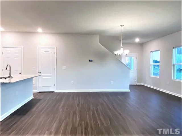 a view of a big room with wooden floor and windows