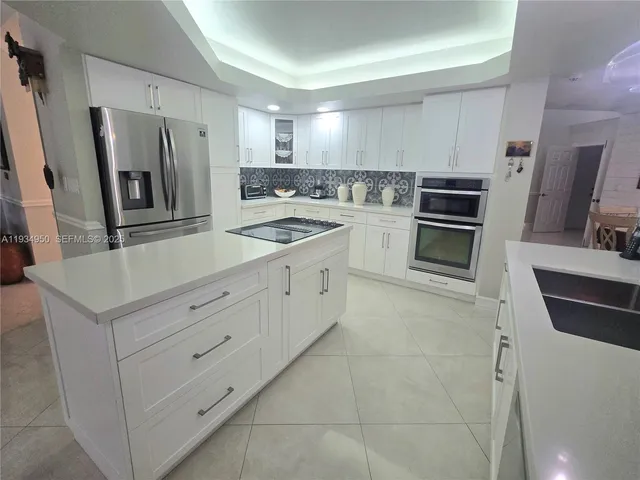 a kitchen with stainless steel appliances a refrigerator sink and stove