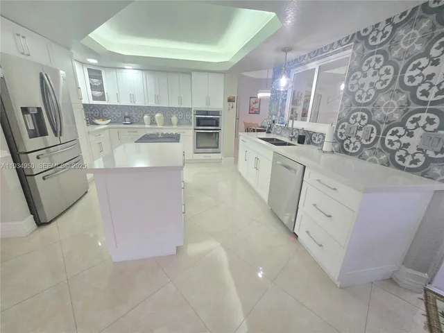 a large kitchen with stainless steel appliances cabinets and a counter top space