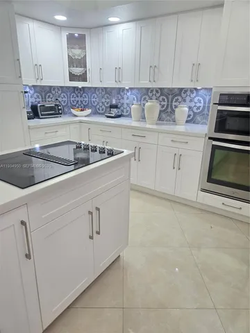 a kitchen with granite countertop white cabinets and white appliances