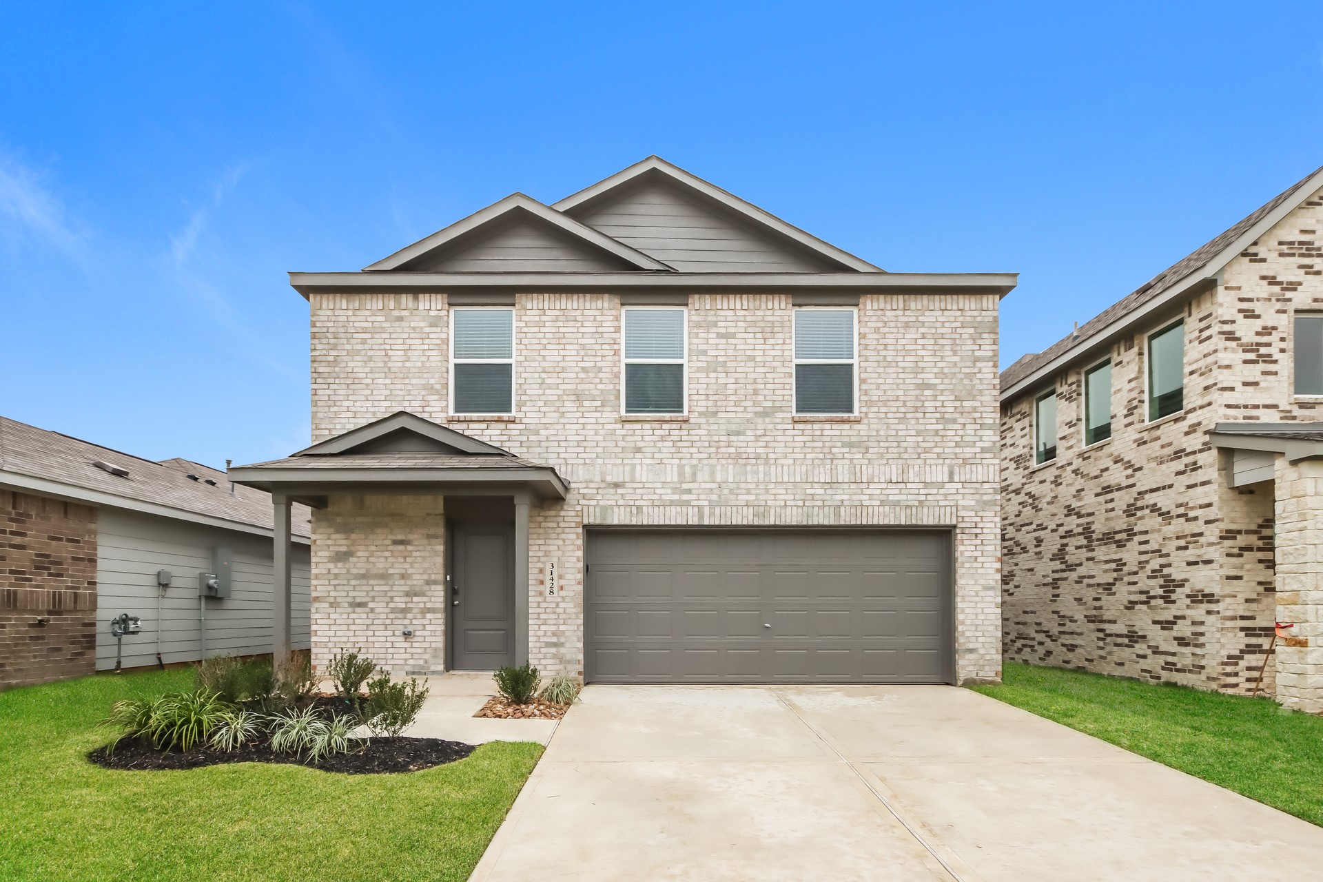 a front view of a house with a garden and yard