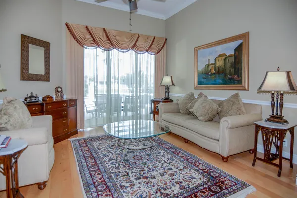 a kitchen with stainless steel appliances kitchen island granite countertop a stove a refrigerator a oven a dining table and chairs with wooden floor