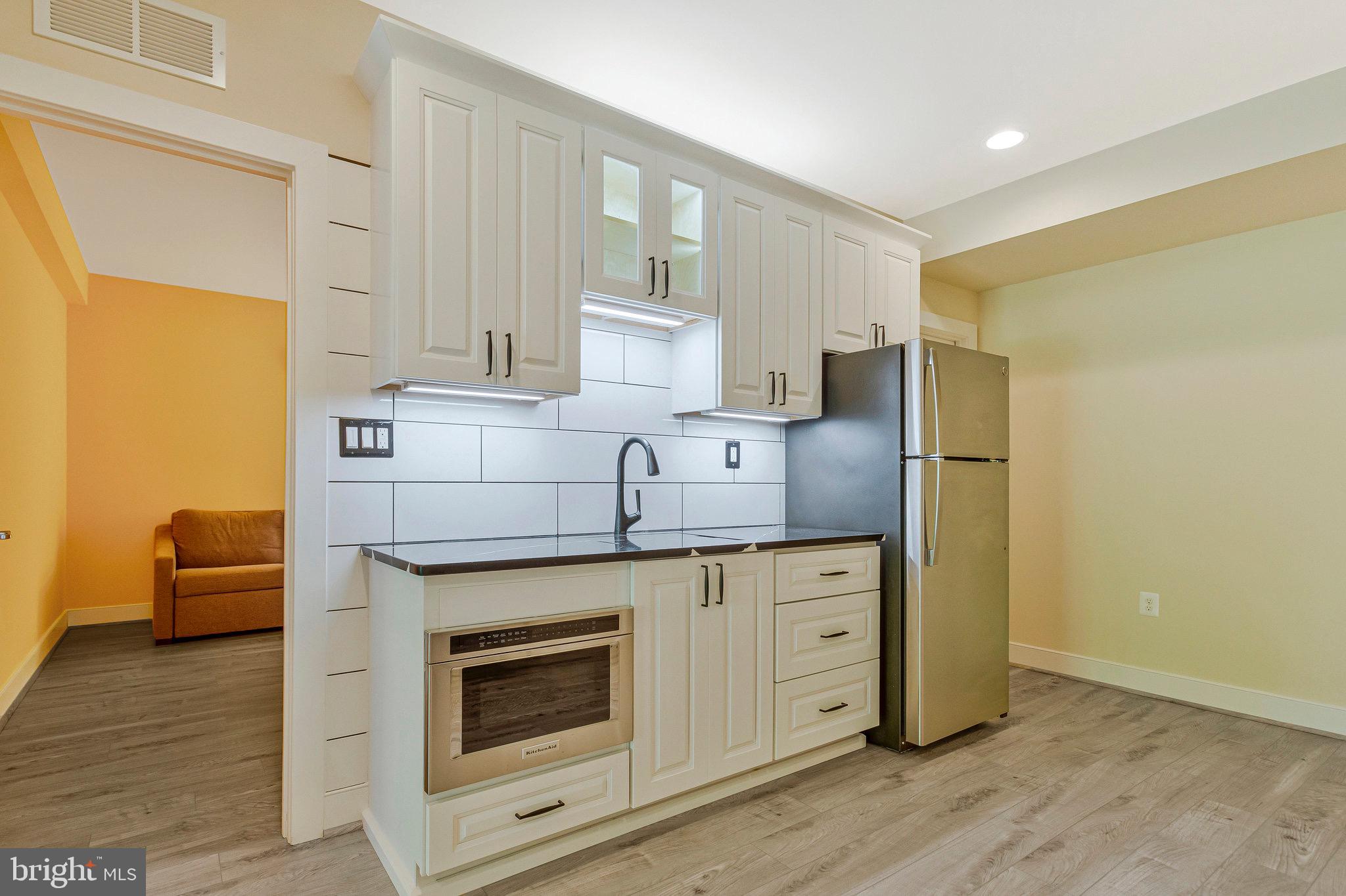9726 Knowledge Drive Laurel, MD 20723 - Photo 34 of 54 a kitchen with stainless steel appliances white cabinets and wooden floors