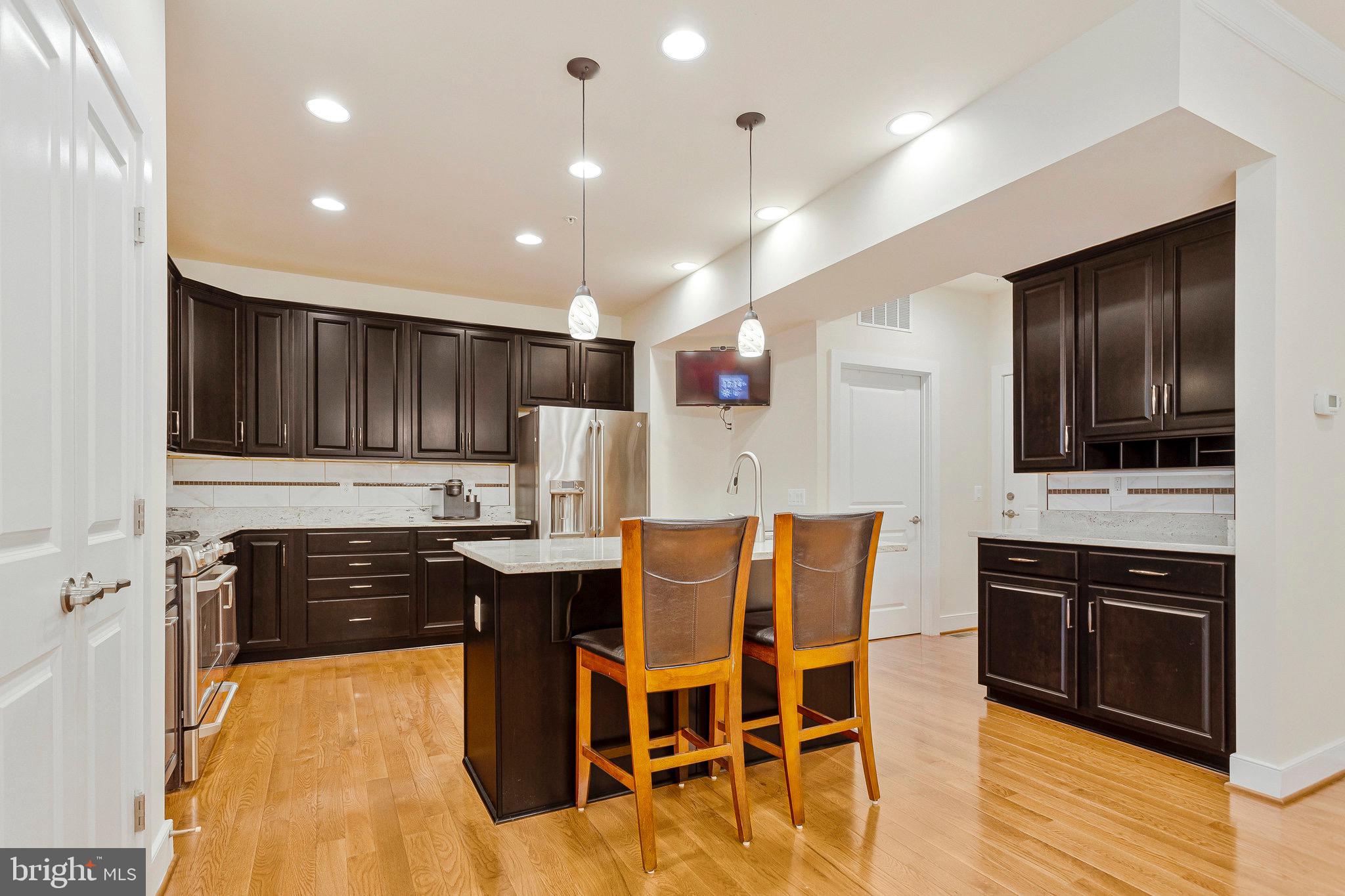 9726 Knowledge Drive Laurel, MD 20723 - Photo 5 of 54 a kitchen with stainless steel appliances kitchen island granite countertop a stove a sink and a refrigerator