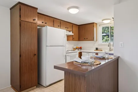 a kitchen with stainless steel appliances granite countertop a refrigerator a sink and a stove