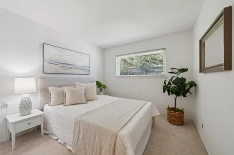 a bedroom with a bed and a potted plant