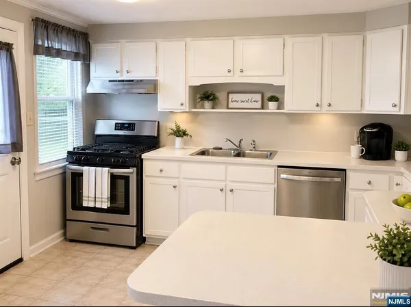 a kitchen with granite countertop white cabinets and white appliances