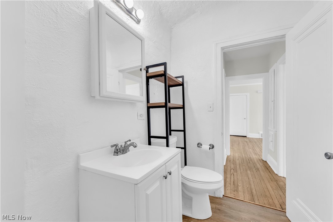 3318 Milverton Road, Unit 1/DN Shaker Heights, OH 44120 - Photo 19 of 21 The bathroom features a vanity with an integrated sink, a toilet, a wall-mounted medicine cabinet with a mirror, and a wall-mounted light fixture