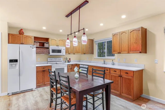 a kitchen with a table chairs refrigerator and microwave
