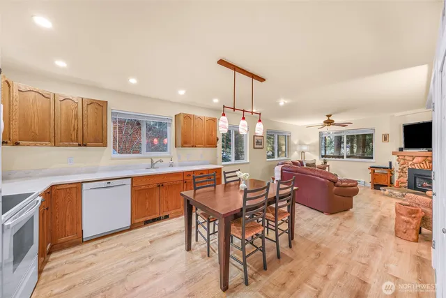 a kitchen with stainless steel appliances granite countertop a table and chairs in it