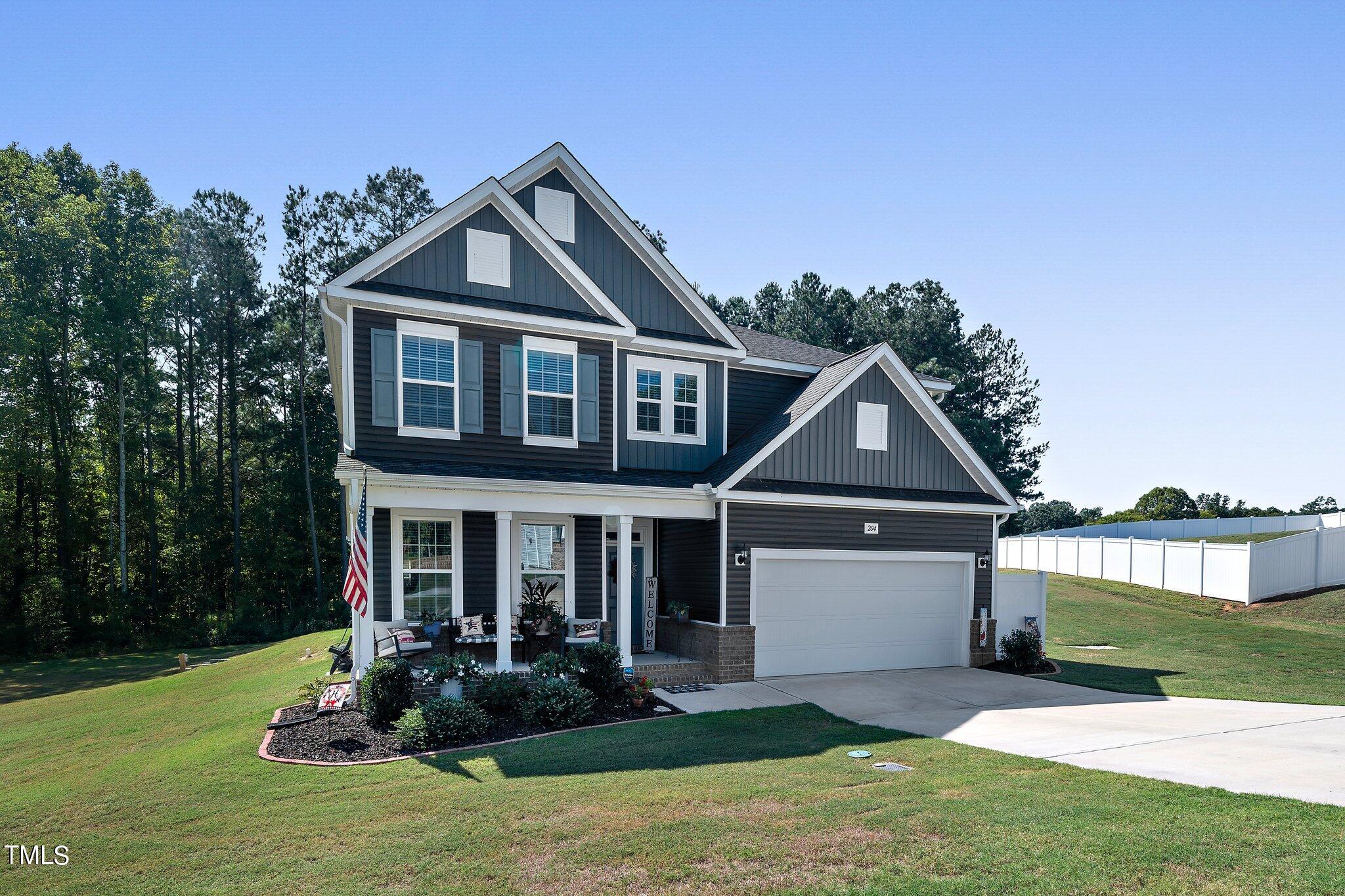 204 Stephens Timberline View Clayton, NC 27520 - Photo 42 of 43 a front view of a house with a yard and potted plants
