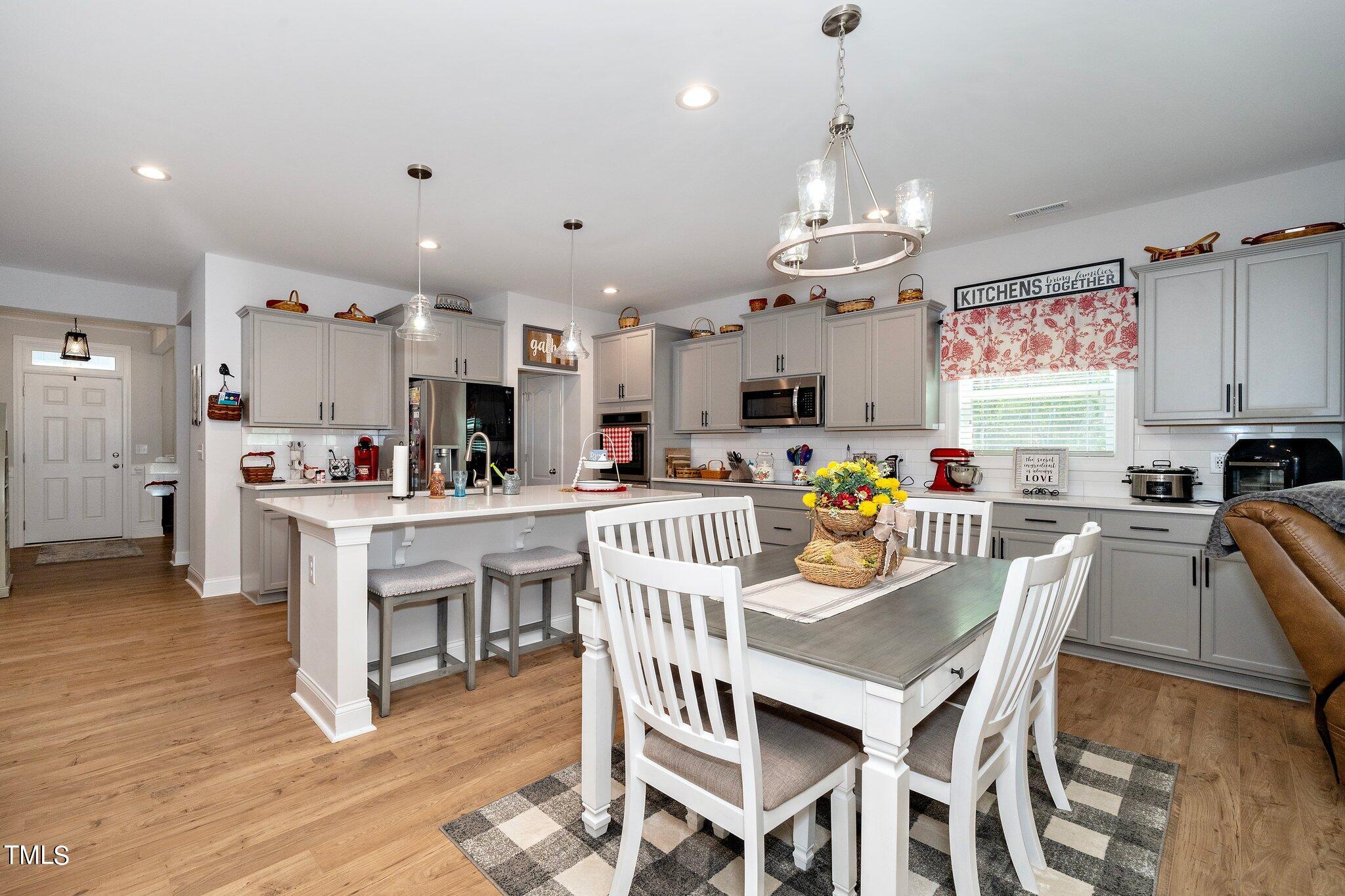 204 Stephens Timberline View Clayton, NC 27520 - Photo 9 of 43 a view of a dining room with furniture a chandelier and wooden floor