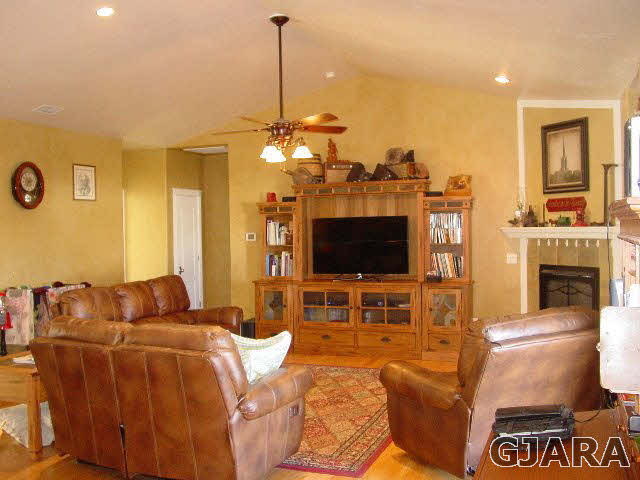2502 Riata Ranch Road Grand Junction, CO 81505 - Photo 2 of 31 a living room with furniture a flat screen tv and a chandelier