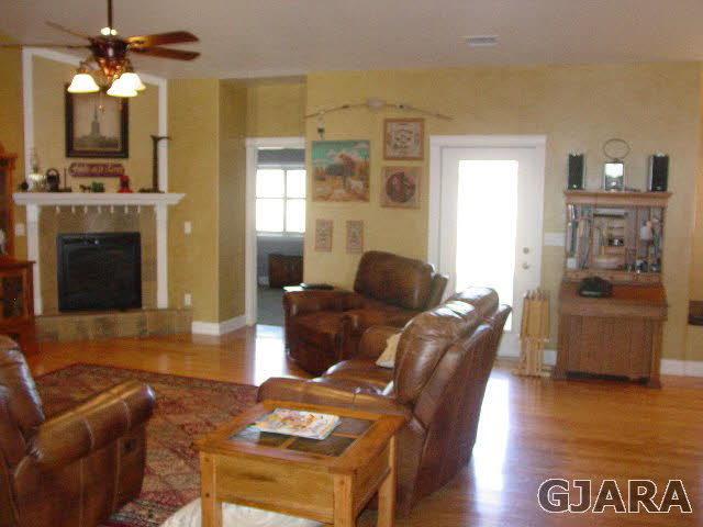 2502 Riata Ranch Road Grand Junction, CO 81505 - Photo 4 of 31 a living room with furniture a fireplace and a flat screen tv