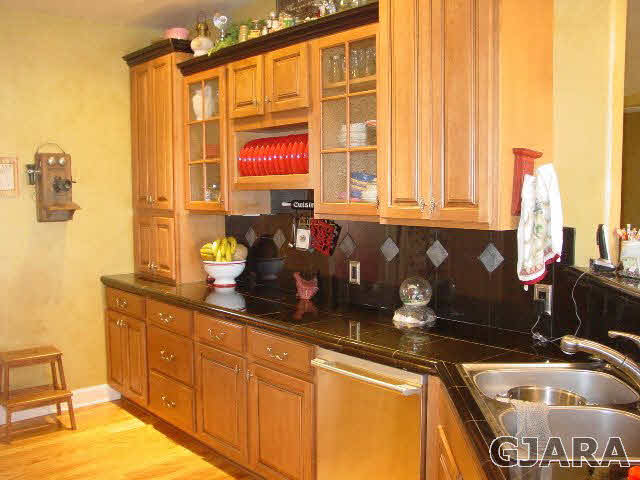 2502 Riata Ranch Road Grand Junction, CO 81505 - Photo 5 of 31 a kitchen with granite countertop a sink and a white wooden cabinets