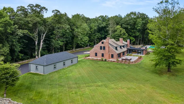 an aerial view of a house with a big yard and large trees