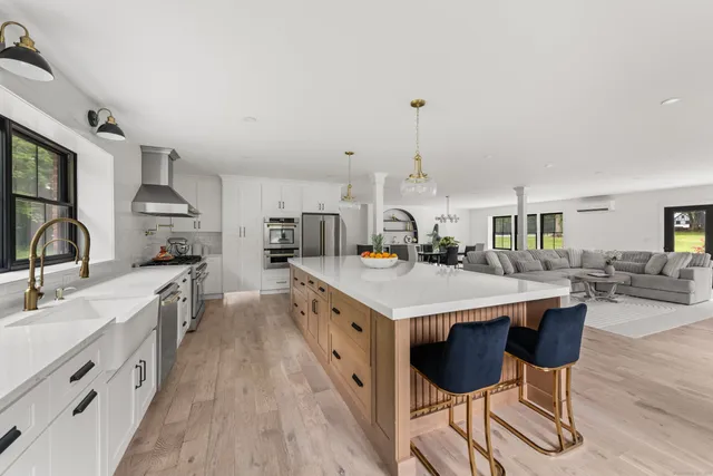 a large kitchen with kitchen island a island a sink a stove and a wooden floor