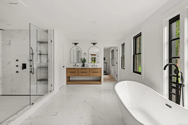 a spacious bathroom with a tub sink and mirror