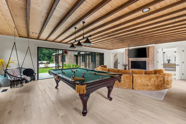 a living room with furniture pool table and a fireplace