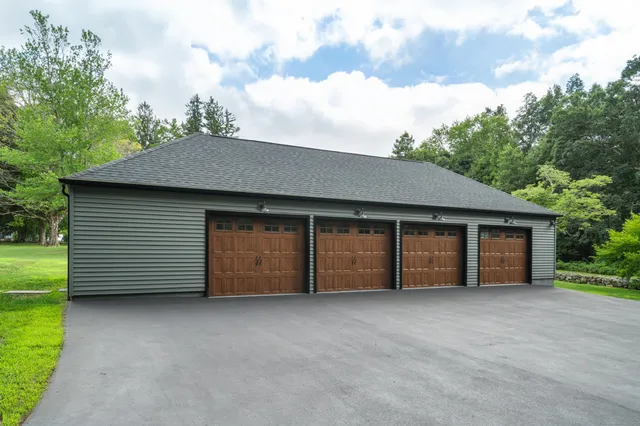 a view of a house with a backyard and garage