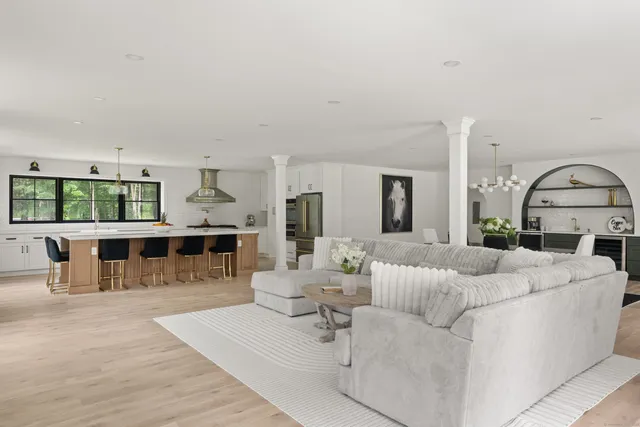 a living room with furniture and view of kitchen