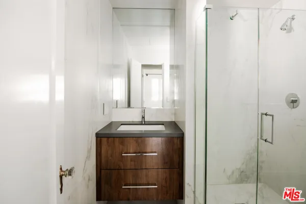 a bathroom with a granite countertop sink and mirror