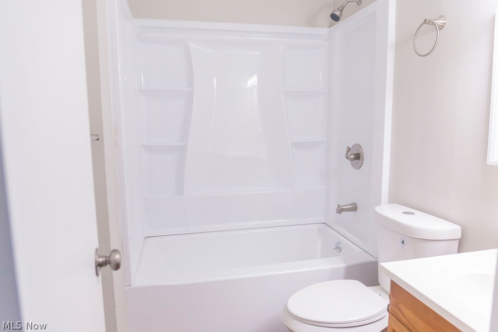3644 Padanarum Road Geneva, OH 44041 - Photo 12 of 19 Bathtub and shower combination featuring a white surround with built-in shelving, brushed nickel fixtures, and a coordinating toilet