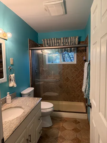 a bathroom with a sink a toilet and shower