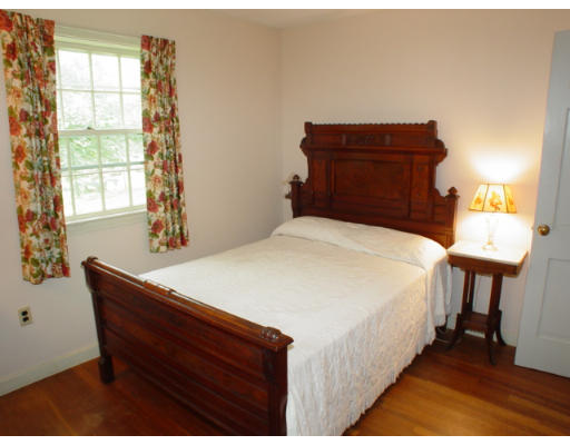 109 Pleasant Valley Road Amesbury, MA 01913 - Photo 4 of 8 a bed sitting in a bedroom next to a window