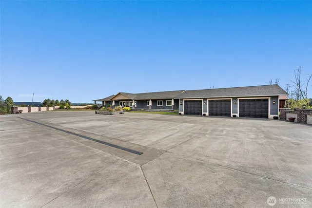a front view of a house with a garden and trees
