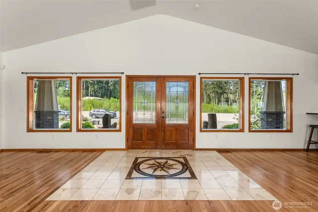 a view of a livingroom with a floor to ceiling window and wooden floor