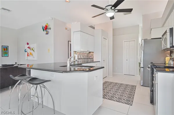 a kitchen with stainless steel appliances granite countertop a refrigerator a stove a sink and a stove